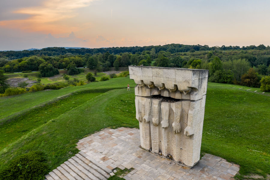 Modern monument and grass-covered hills at the former Płaszów camp